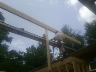 Carpenter setting a ridge beam over a new addition frame — Ice Dam Removal by Roofing Brothers in Blanding