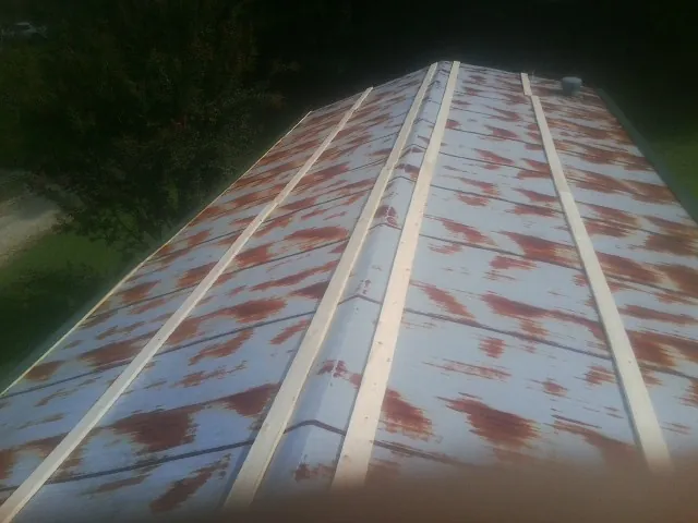 Rusted metal roof panels with new wood purlins before replacement — Storm Damage Roof Repair in Blanding by Roofing Brothers